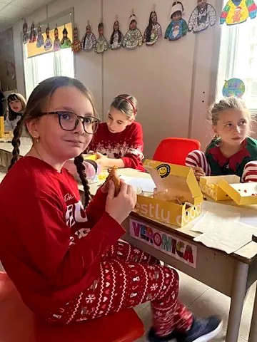 Students at their classroom desks eating Honestly Good lunch boxes on a pyjama day